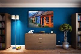 Pièce avec buffet et bibliothèque, mur bleu canard avec tableau accroché et plante