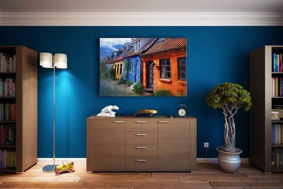 Pièce avec buffet et bibliothèque, mur bleu canard avec tableau accroché et plante