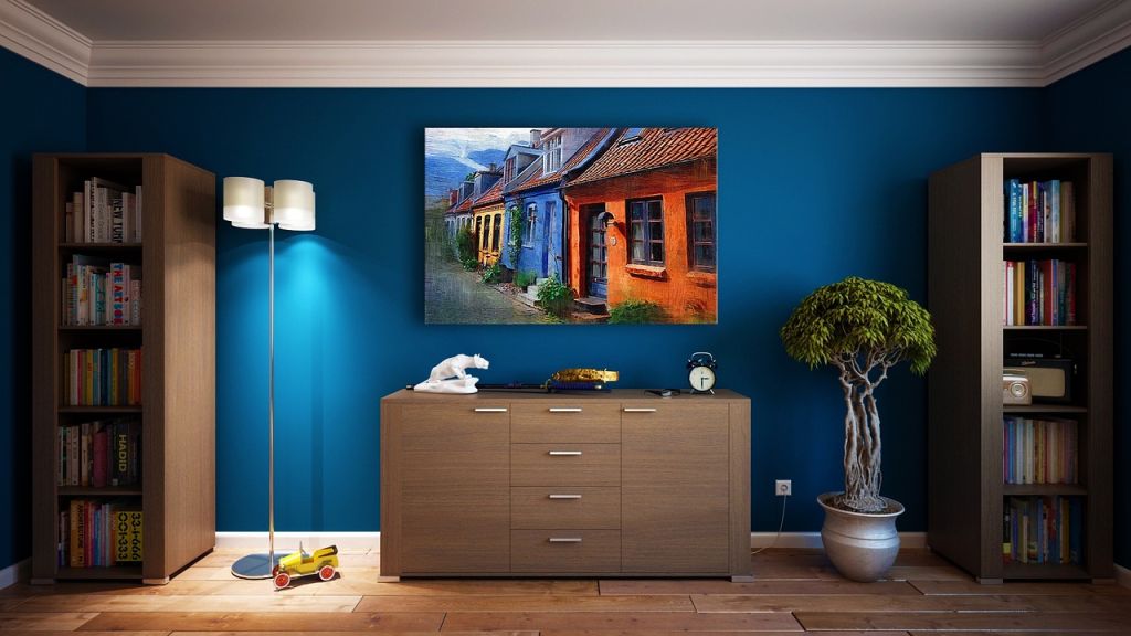 Pièce avec buffet et bibliothèque, mur bleu canard avec tableau accroché et plante